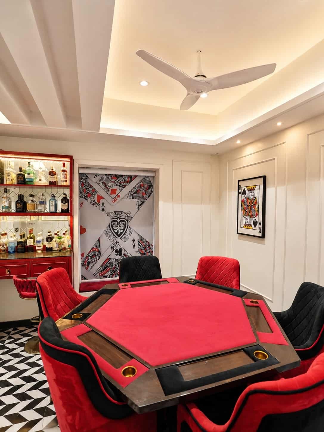 Games room with a red octagonal poker table and red chairs under a panelled ceiling