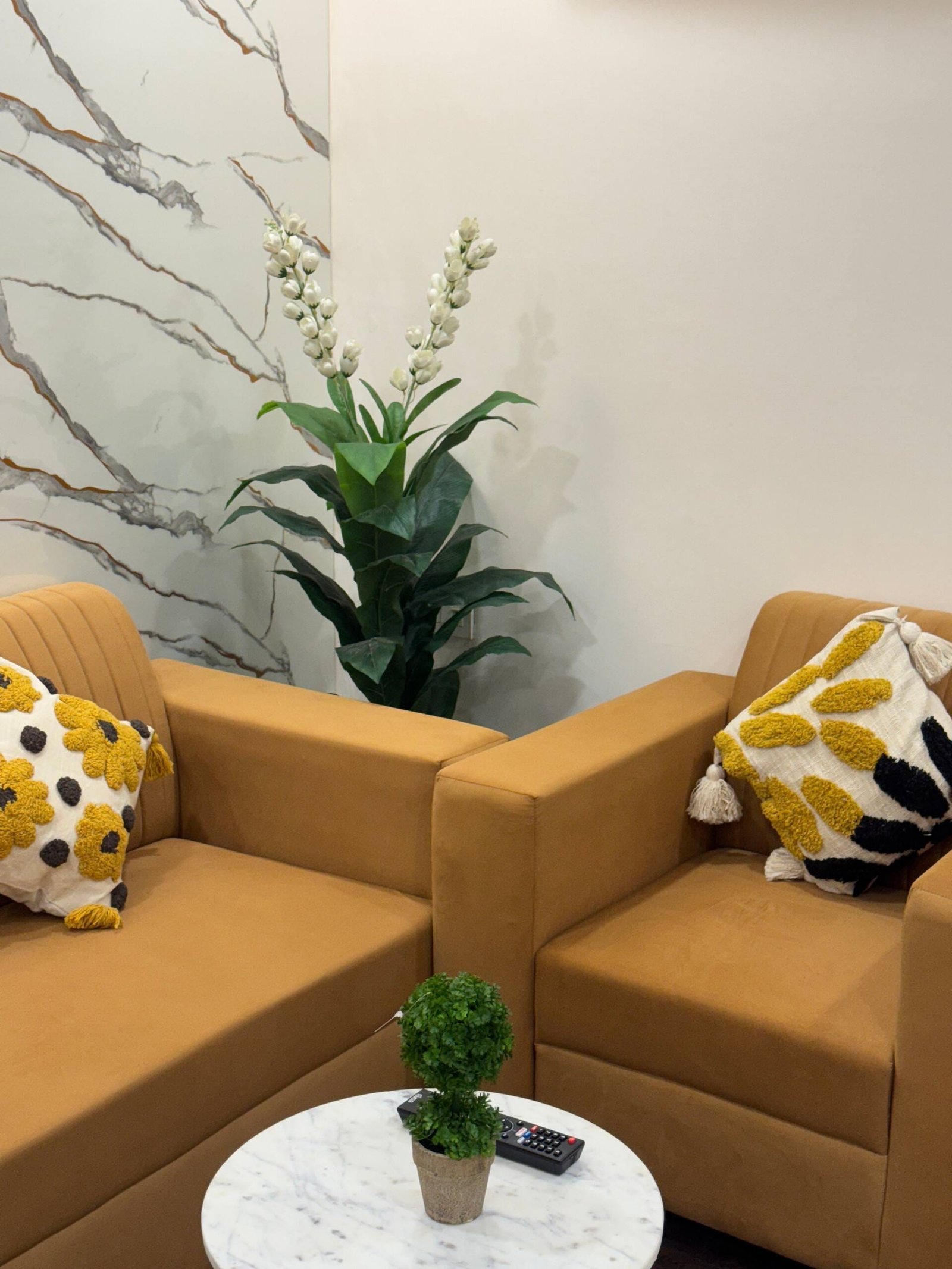 Two mustard armchairs around a small round white table