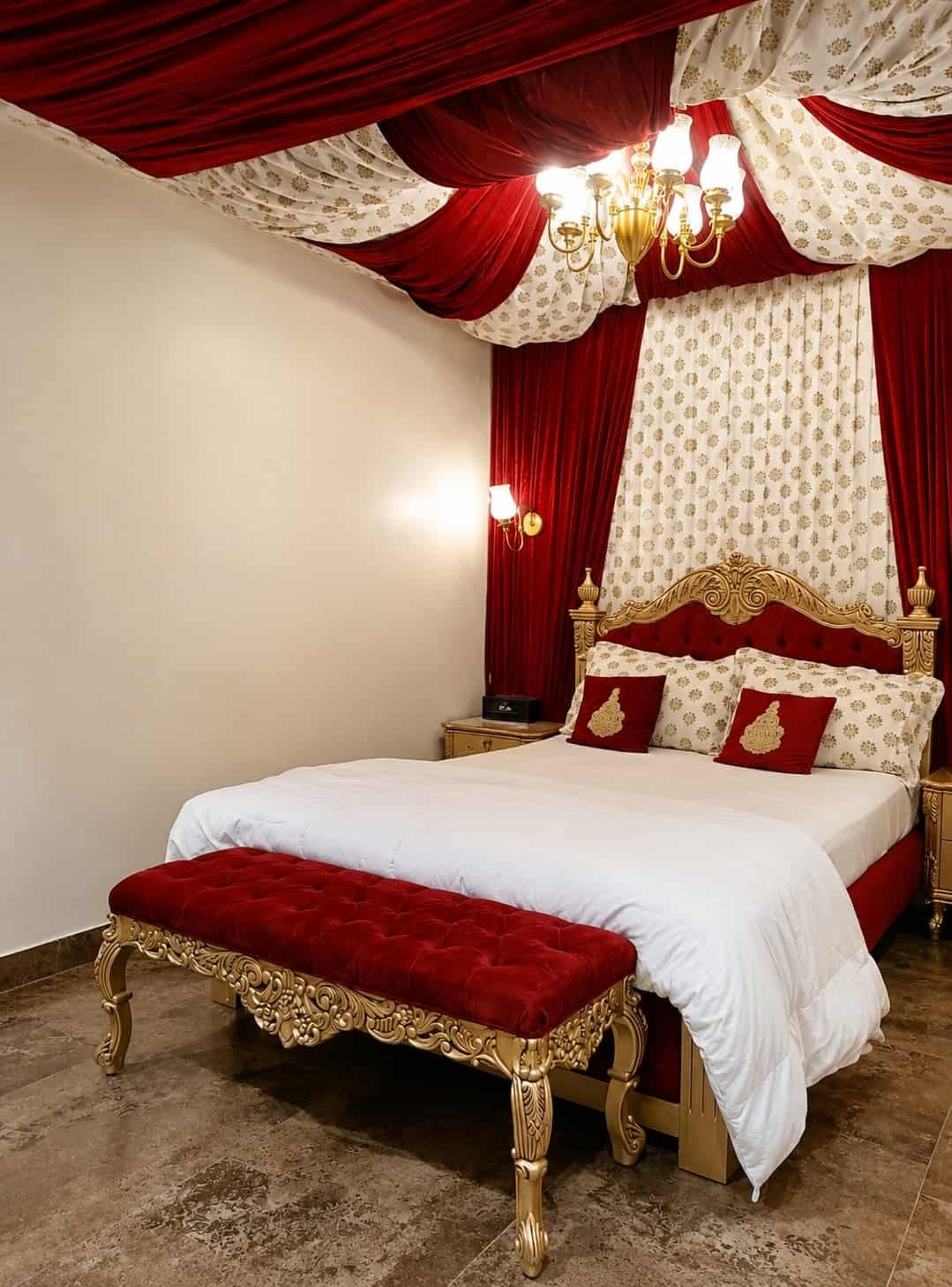 Bedroom 3 with a gilded headboard and red drapes under a chandelier