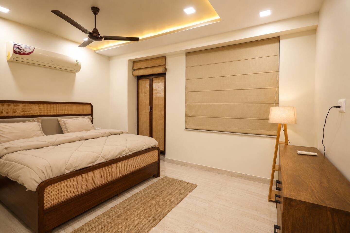 Bedroom 1 with a cane-panel bed, side table and floor lamp