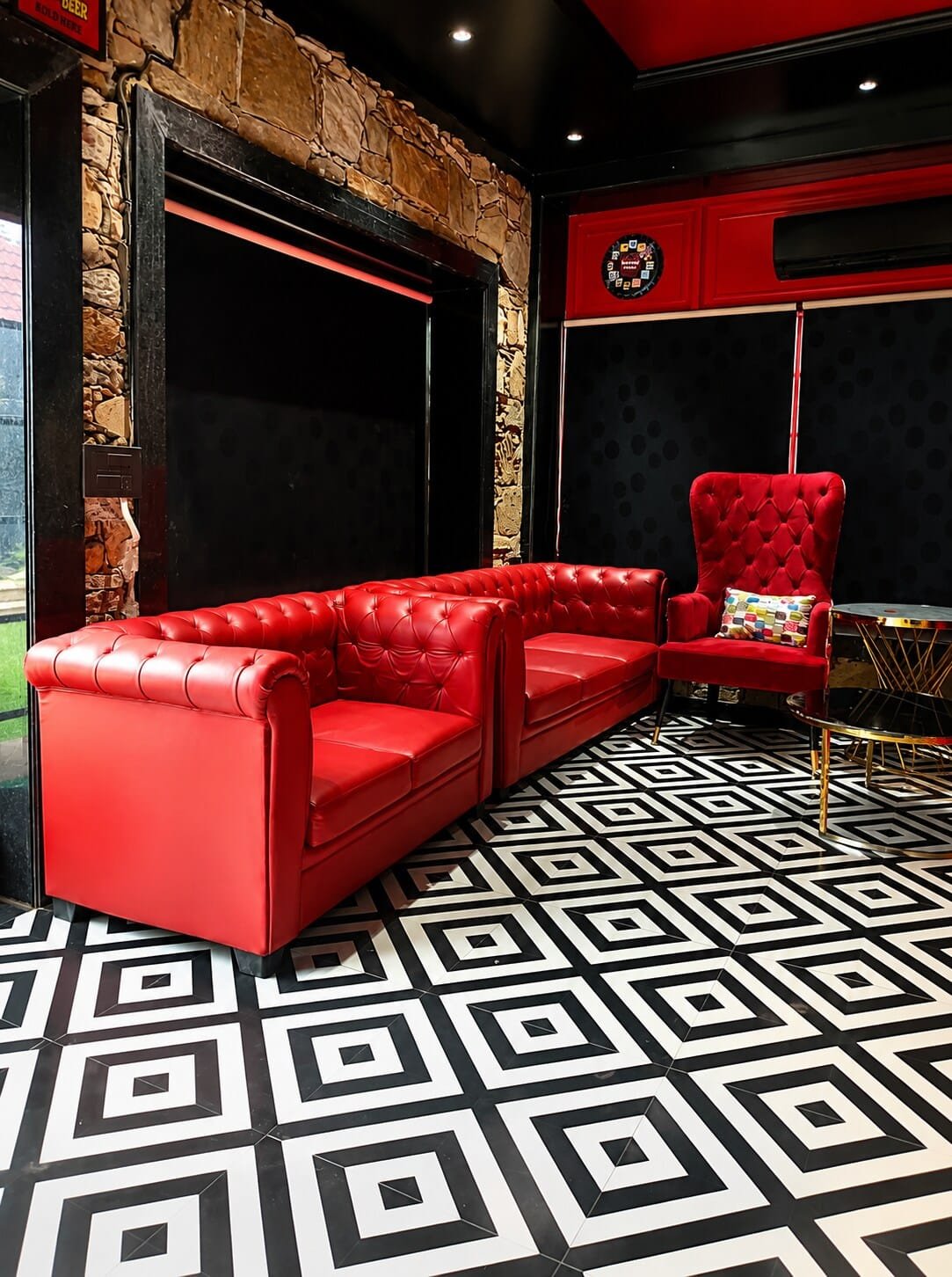 Lounge with red tufted leather sofas on a black-and-white floor