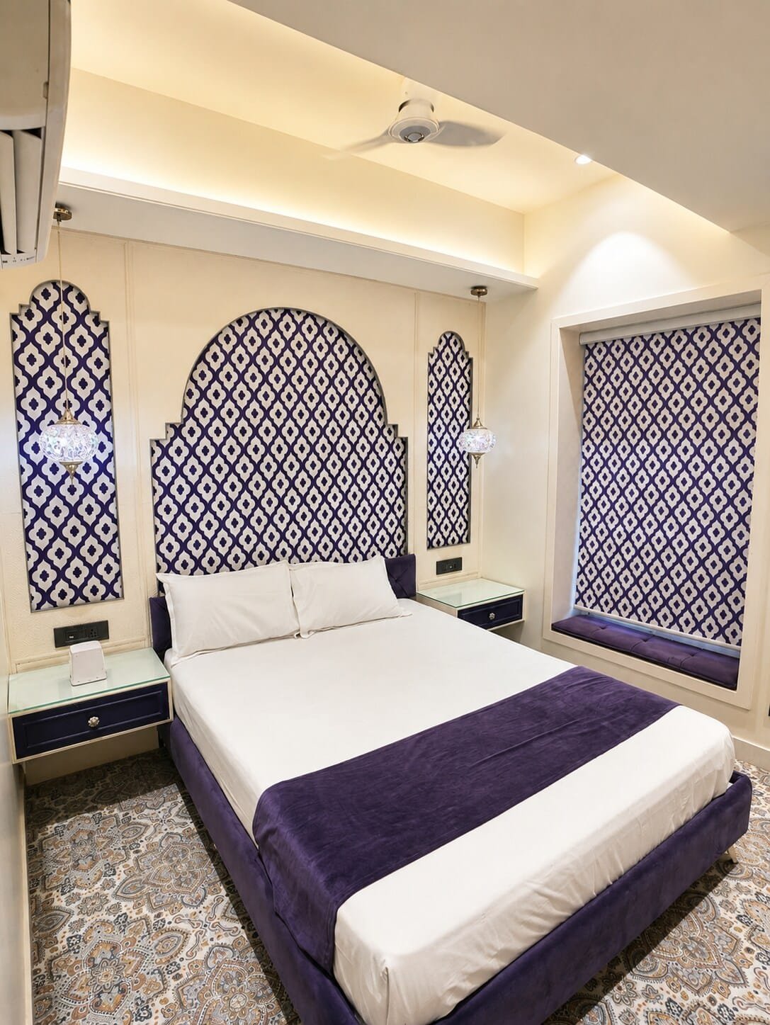 Bedroom 2 with purple bedding and blue-and-white lattice window arches