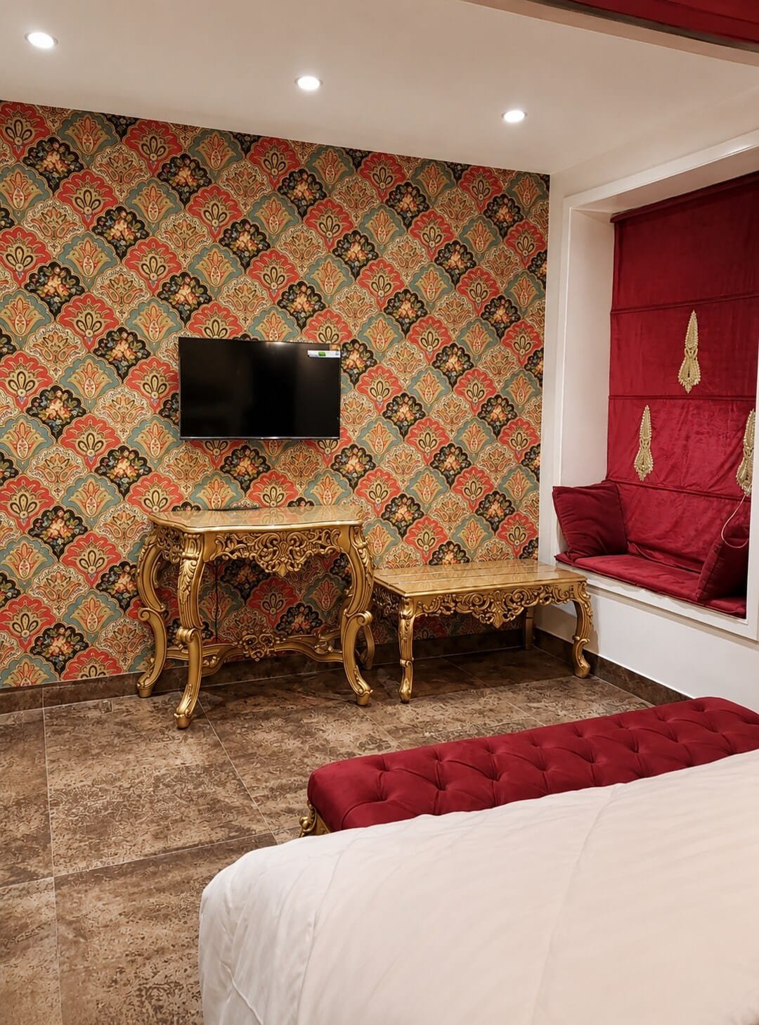 Seating nook with a gilded side table and red window seat