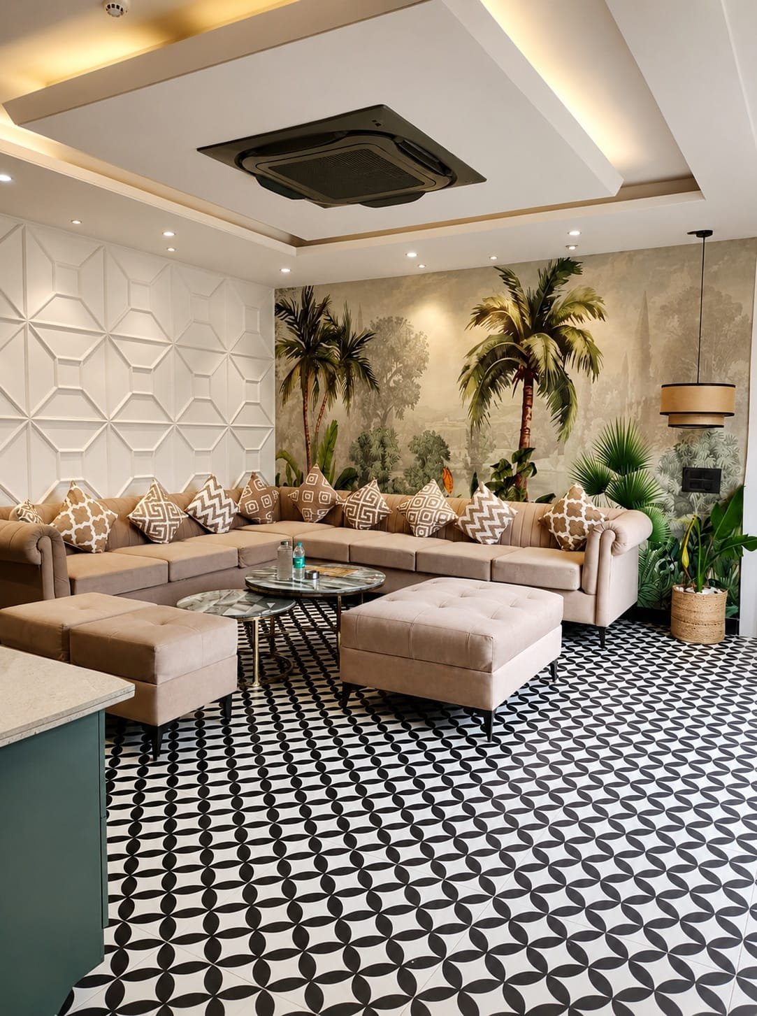 Lounge with a large sectional sofa, palm plants and geometric floor tiles