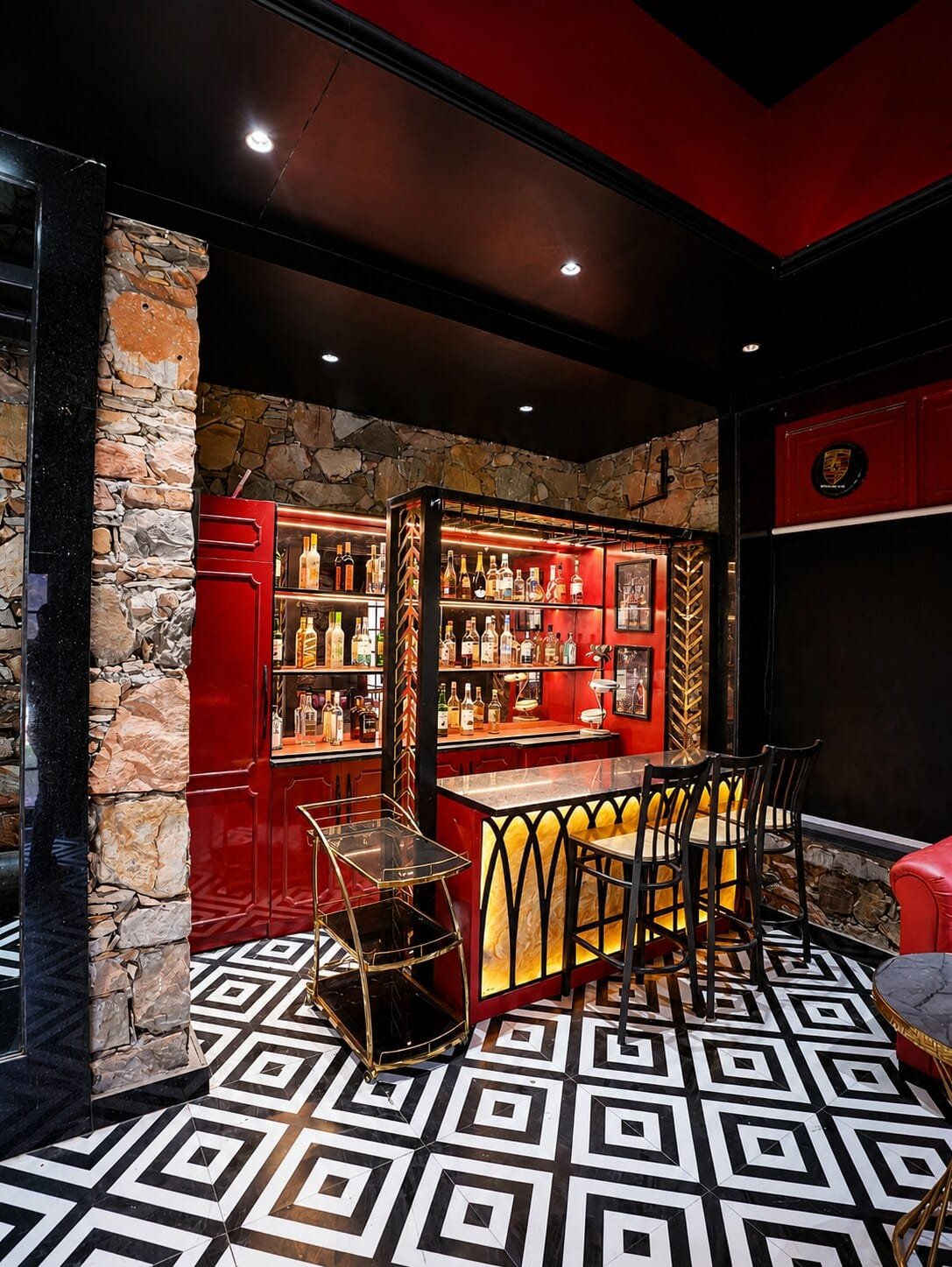 Bar counter with red shelving and stone walls over a black-and-white floor