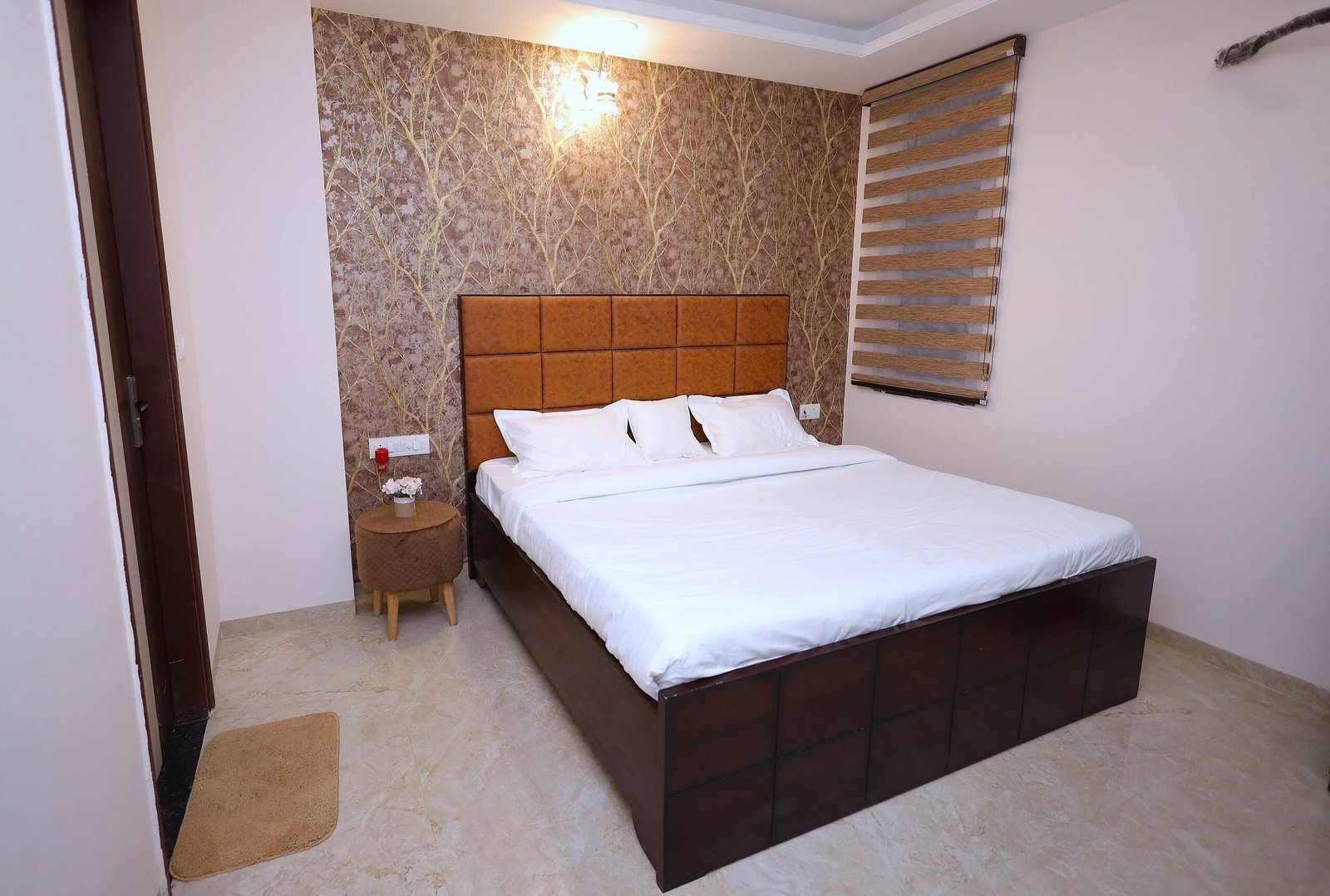 Bedroom 2 with a tan padded headboard and patterned wallpaper