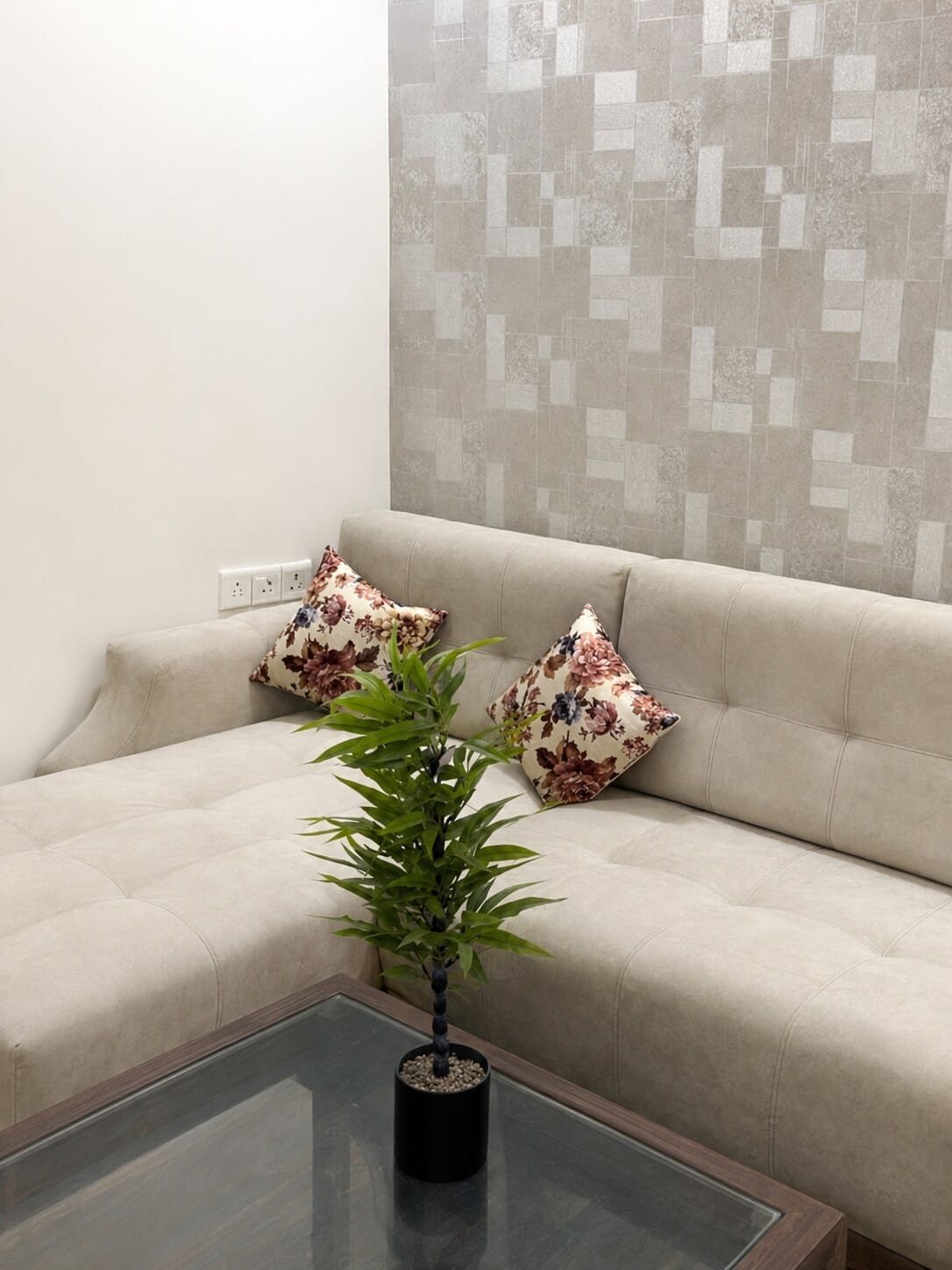 Corner sofa with a plant on a glass coffee table