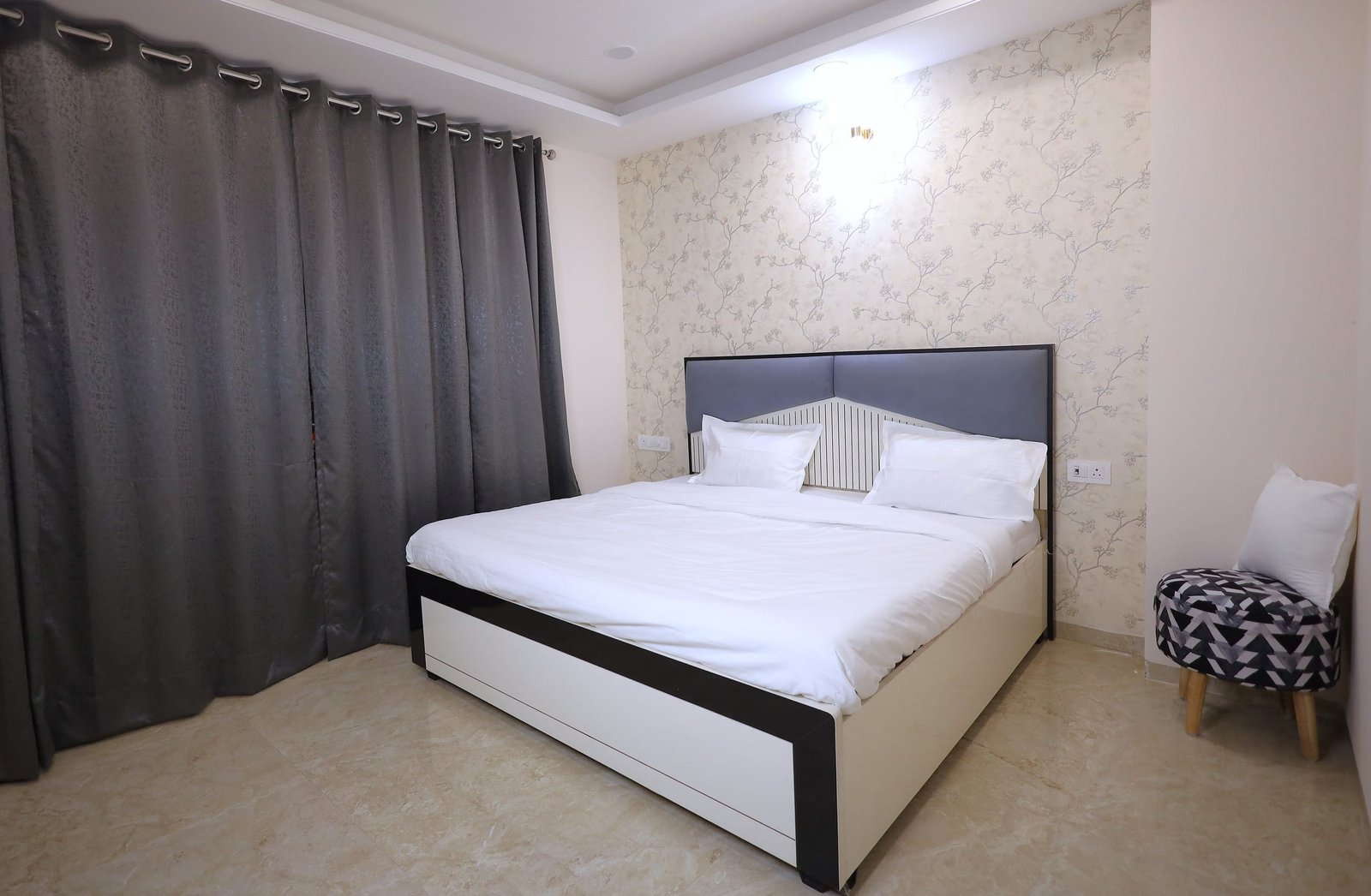 Bedroom 2 with a white bed, grey headboard and dark curtains