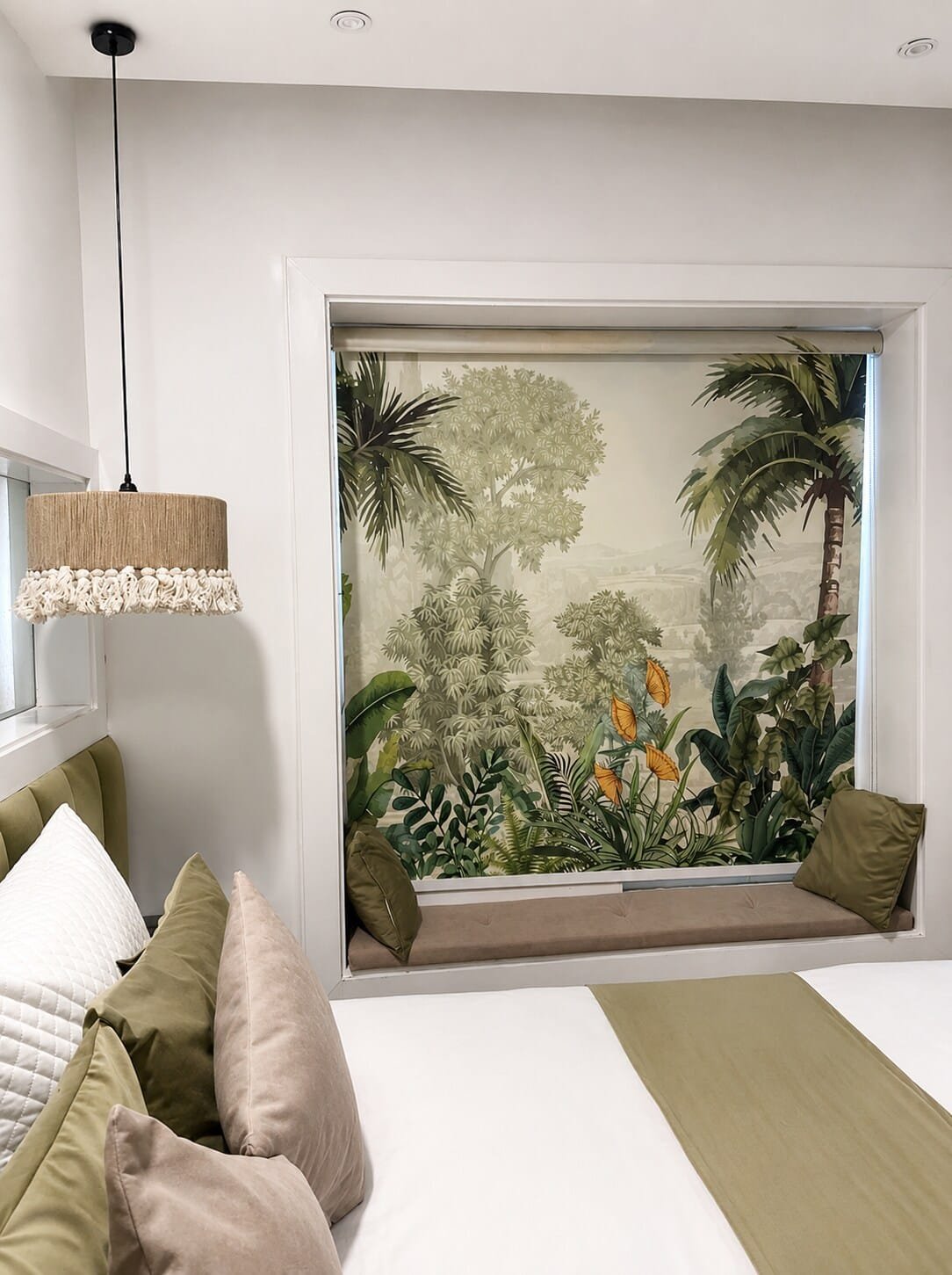 Window seat framed by a botanical mural beside the bed