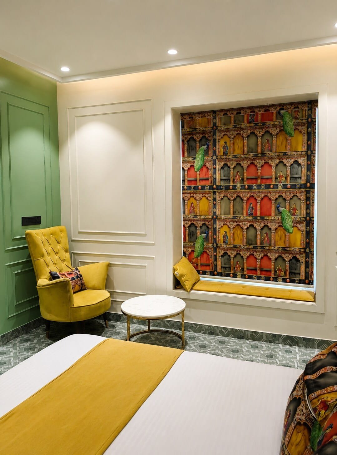 Window seat with a colourful printed blind beside a mustard armchair