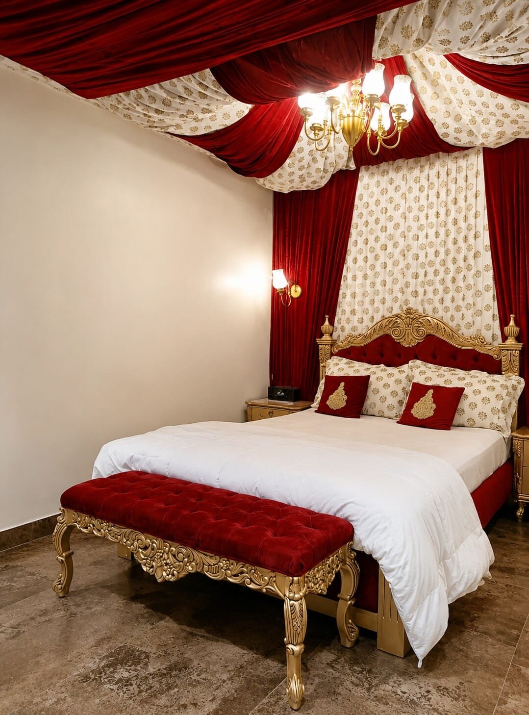 Bedroom with a gilded headboard and red drapes under a chandelier