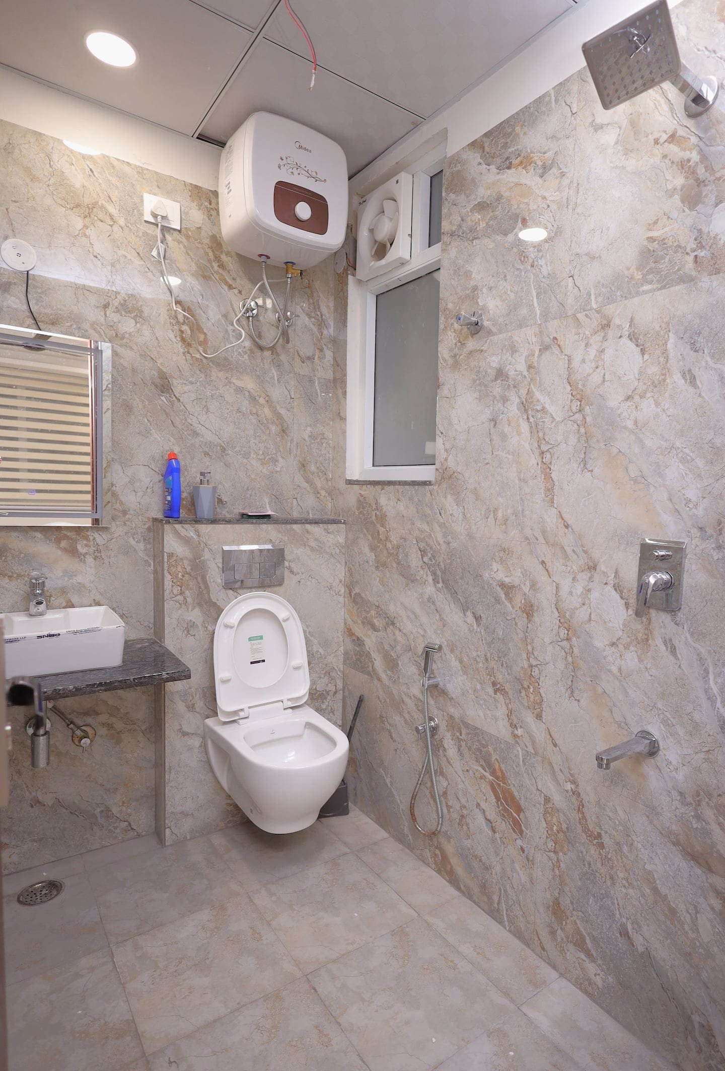 Bathroom with marble-look tiles, a wall-hung toilet and water heater