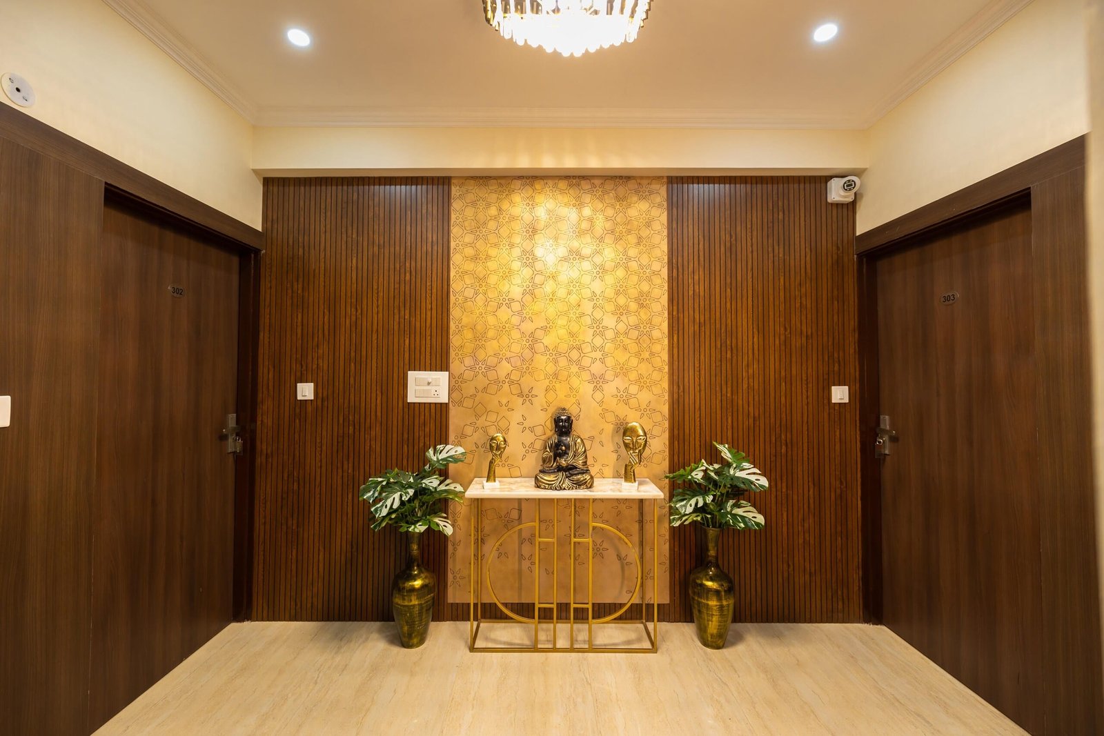 Corridor with wooden panelling, a gold console table and potted plants between room doors