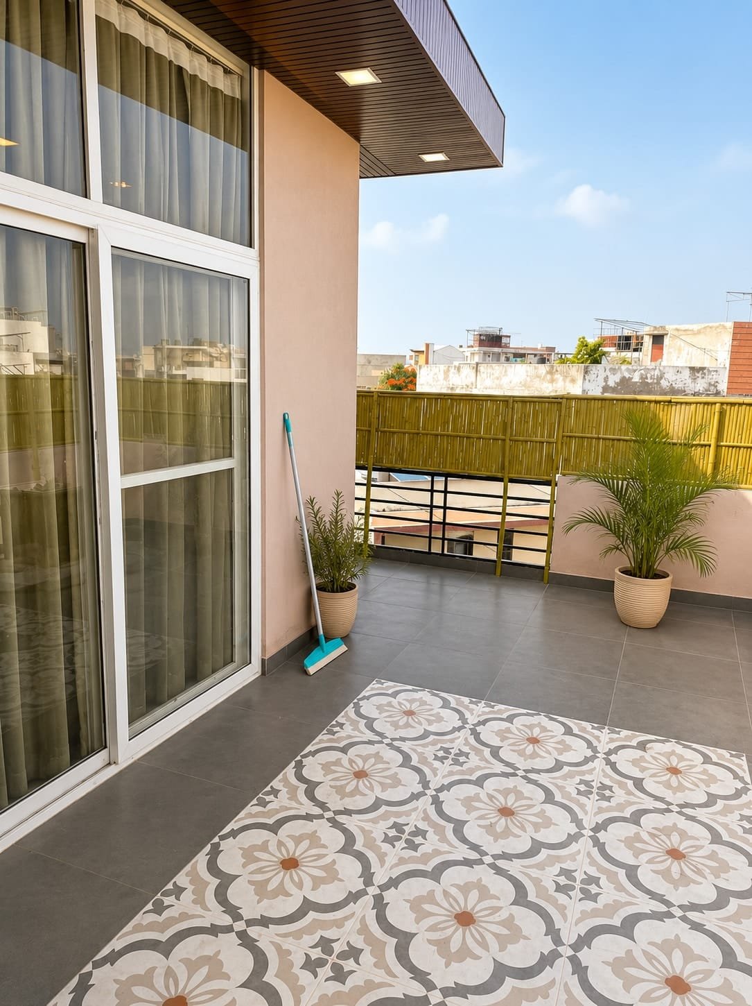 Terrace seen through sliding glass doors, with patterned tiles and potted palms