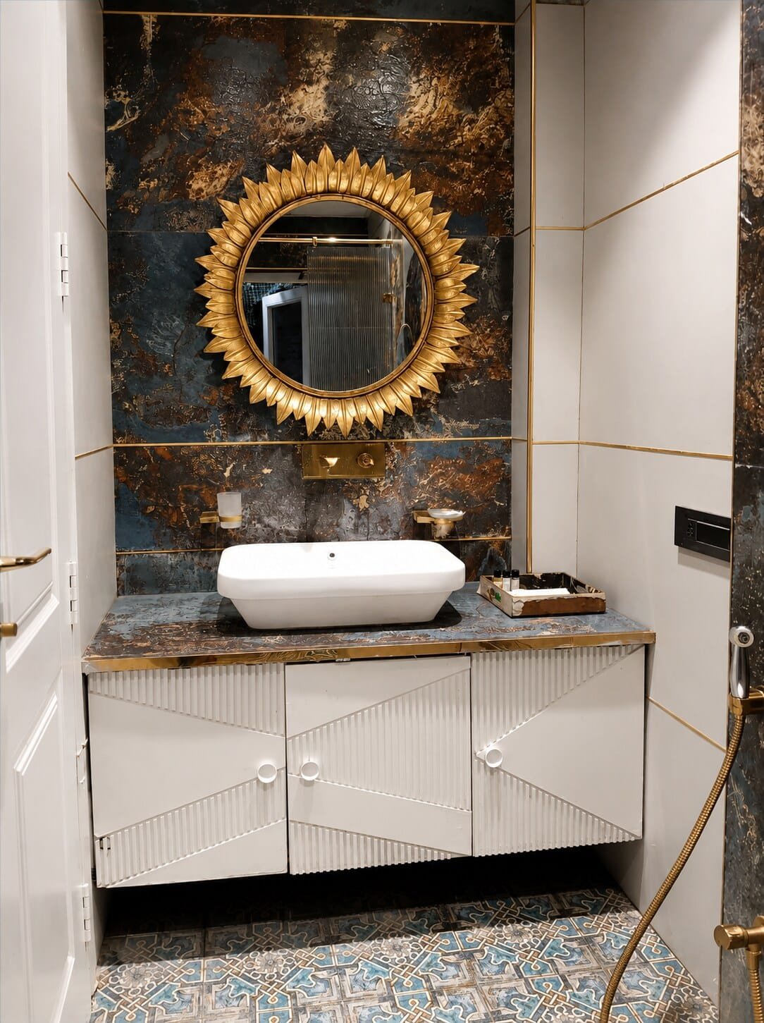 Bathroom with a round gold mirror, vessel basin and dark marble wall