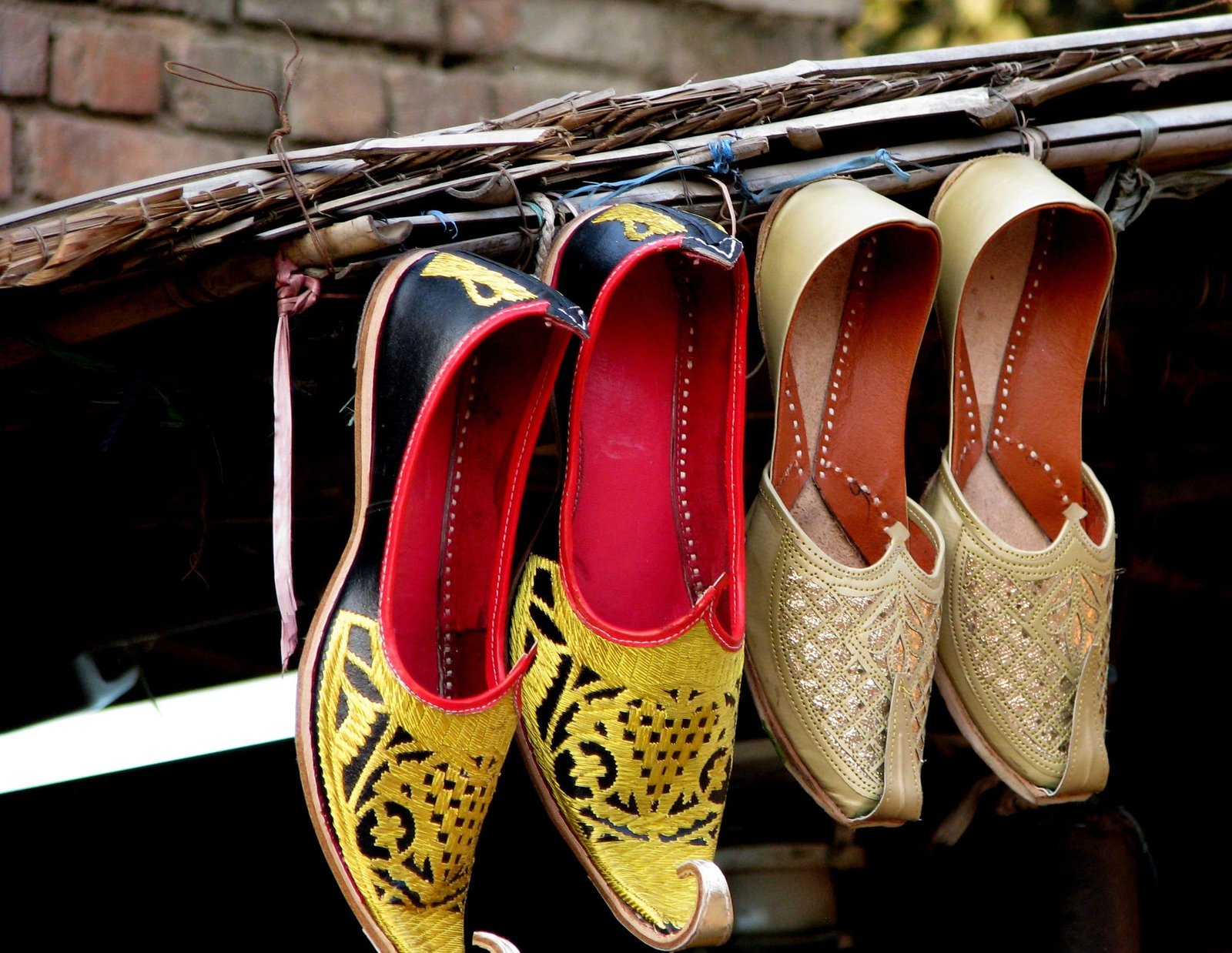 Embroidered juttis hanging in a row outside a shop